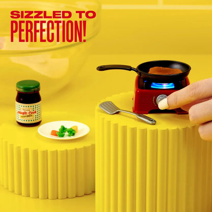 Detalle del playset Mini Brands Magic Cook Kitchen mostrando sartén con mini carne y vegetales